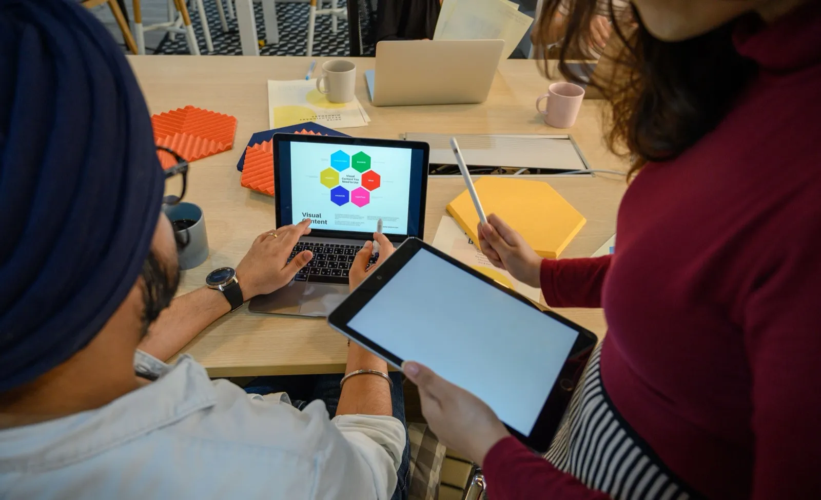 Två kollegor som tittar på en digital mindmap på en surfplatta tillsammans på ett kontor, som symbol för digitalisering
